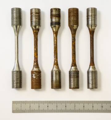 Examples of S460 steel samples prepared for fatigue testing without and with four different levels of corrosion